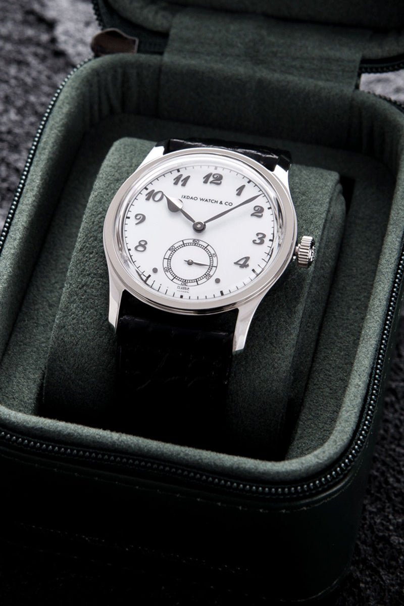 A vintage Grand Champs watch by Swatch & Co. with a white dial and black leather strap, presented inside an open dark green velvet watch box.