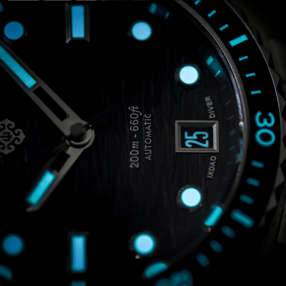 Close-up of a black dial watch with bright cyan luminescent hour markers, hands, and bezel markings, plus a date window showing 25.